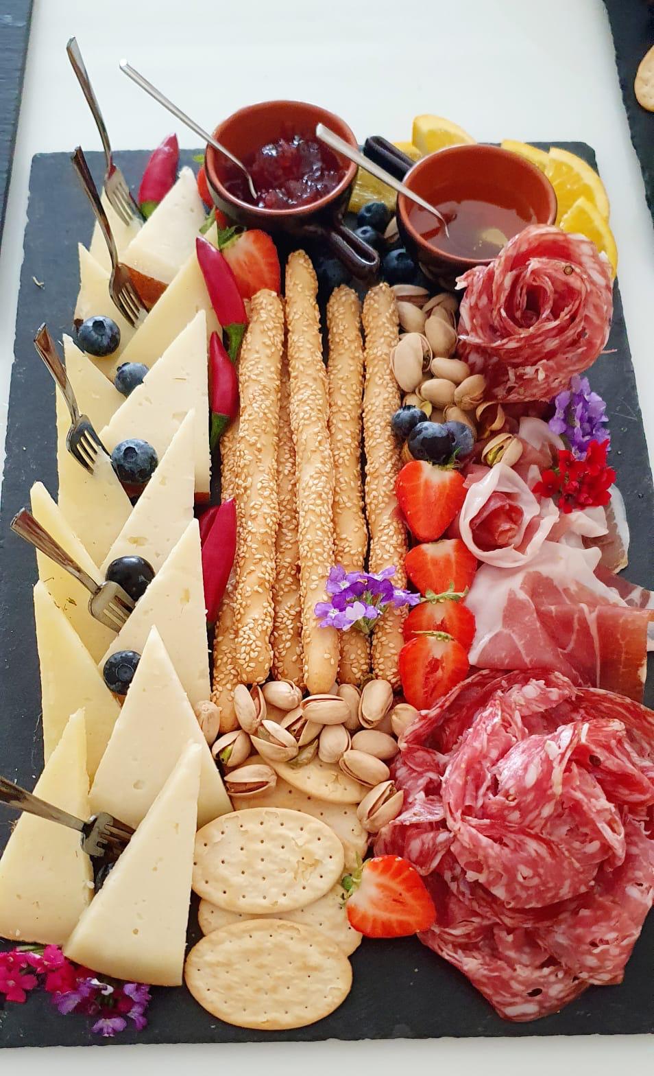 Antipasto board with cheeses, cured meats and fruit prepared for private dining in Tuscany