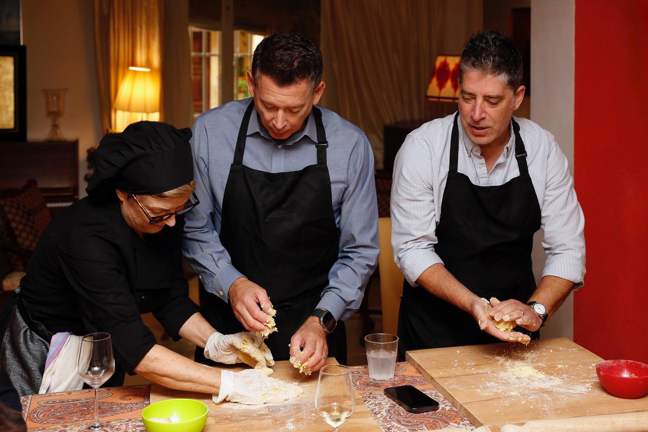 Hands-on cooking lesson in Tuscany with guests learning dough preparation