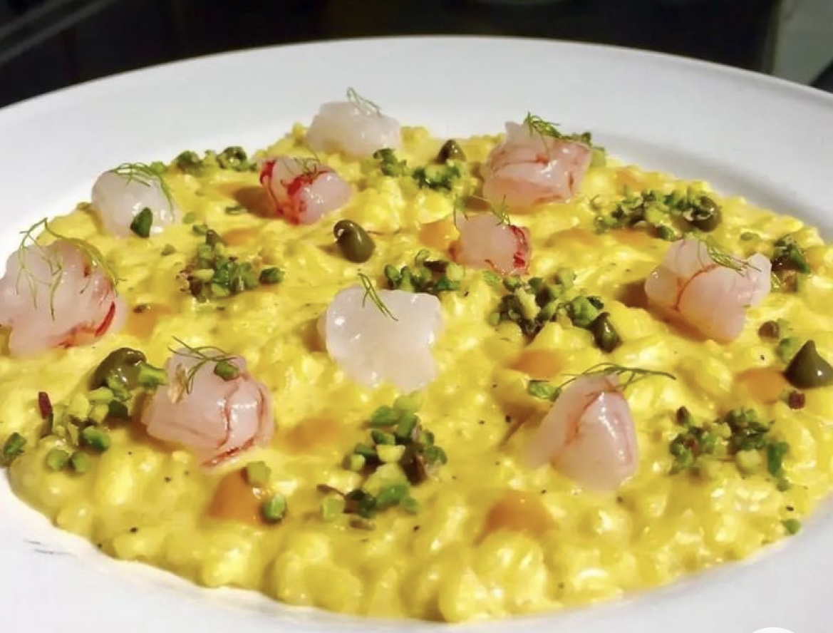 Yellow risotto plated as part of a Tuscan cooking lesson menu