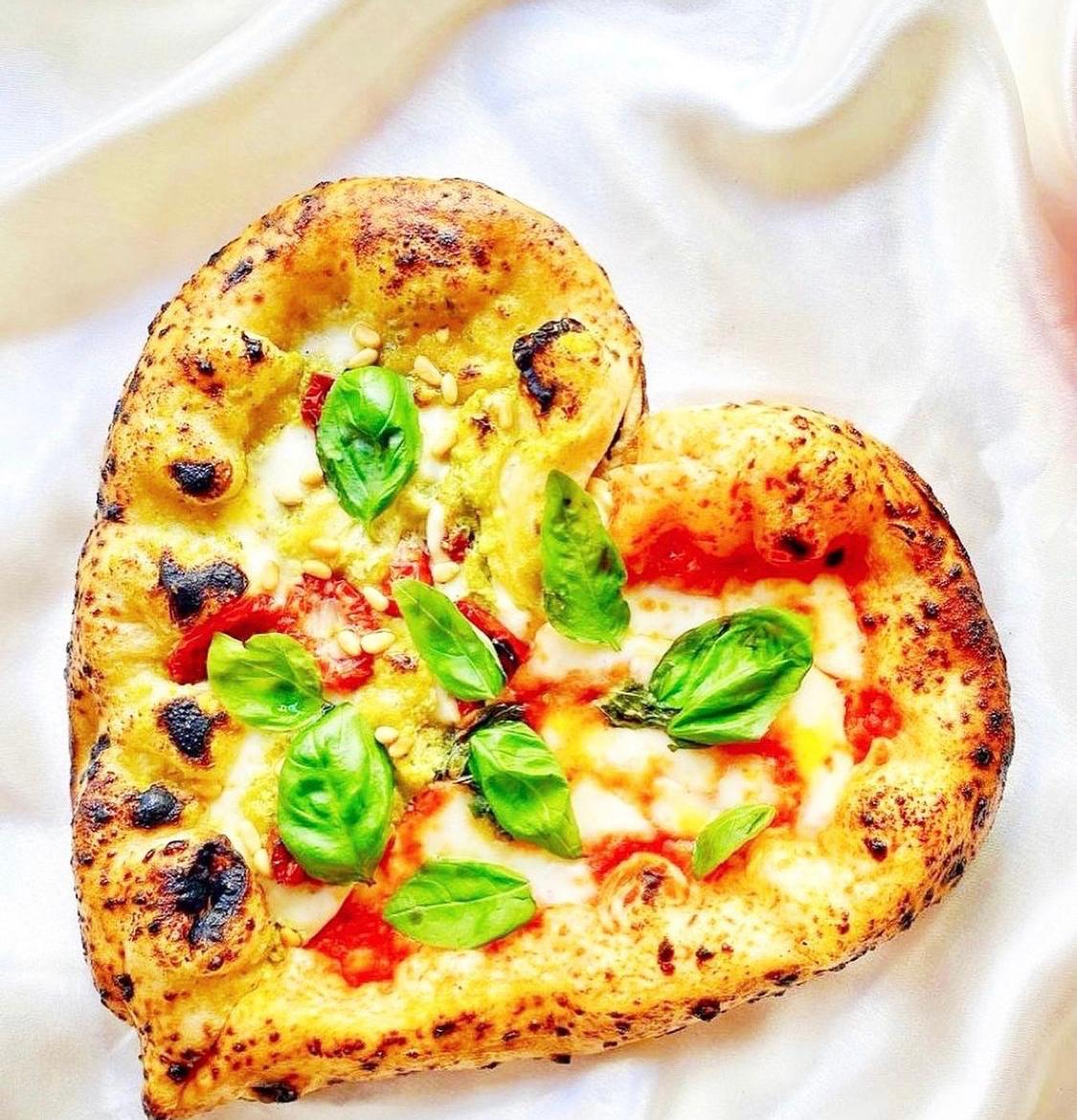 Heart-shaped pizza prepared as part of a playful Tuscan pizza experience